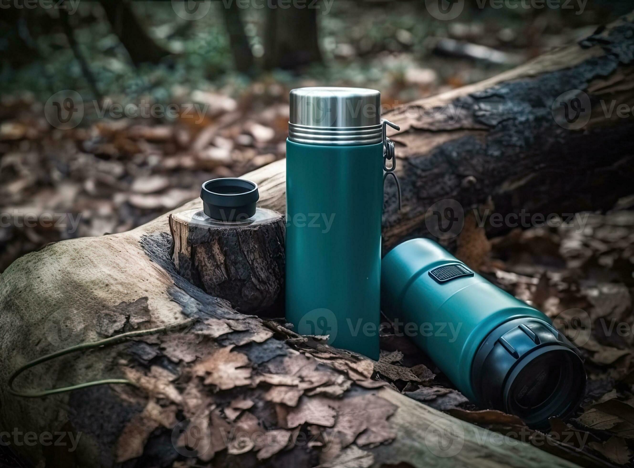 Thermos and aluminum hot drink mug with rising steam outdoors