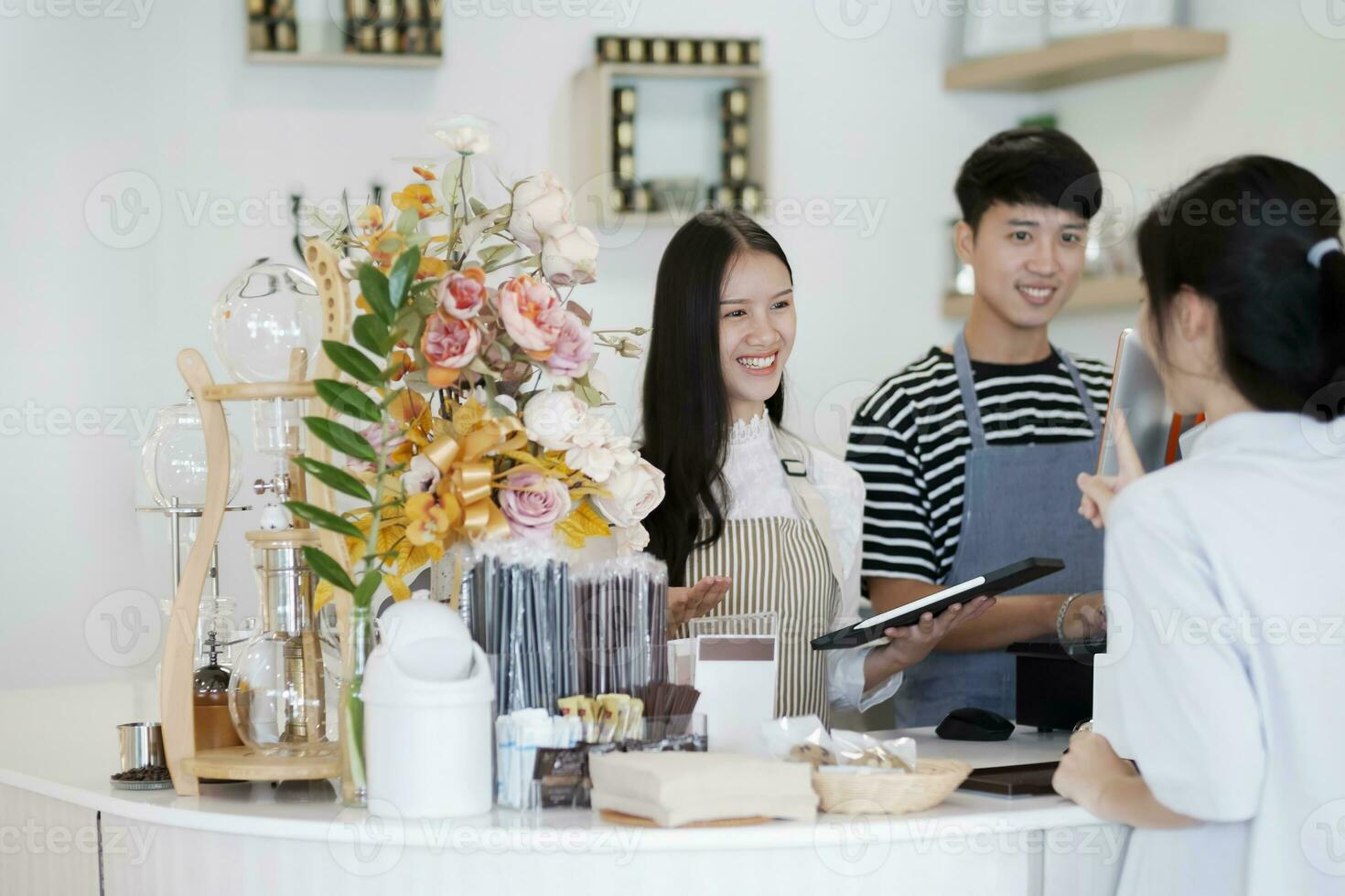 Asia Barista waiter take order from customer in coffee shop, cafe owner writing drink order at counter bar. photo