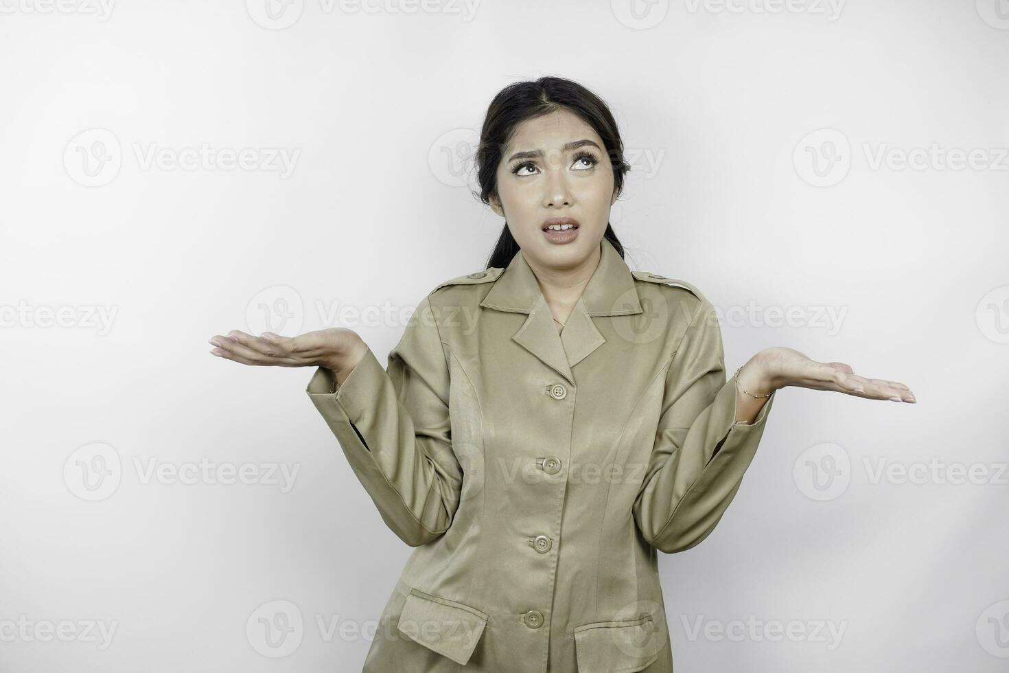 confuso asiático gobierno trabajador mujer tener pensando gestos pns vistiendo un caqui uniforme. foto