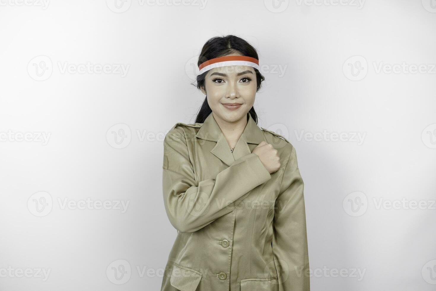 Proud government worker woman gesturing salute pose isolated by white background. PNS wearing khaki uniform. Indonesia's independence day concept. photo