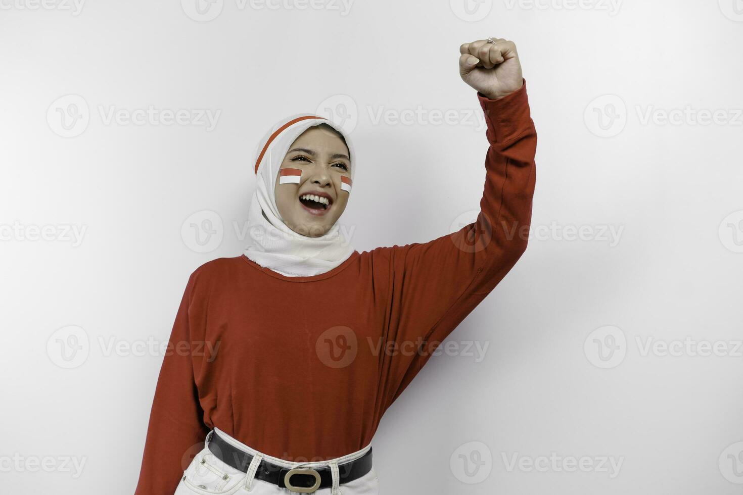 A young Asian muslim woman with a happy successful expression wearing red top and white hijab isolated by white background. Indonesia's independence day concept. photo