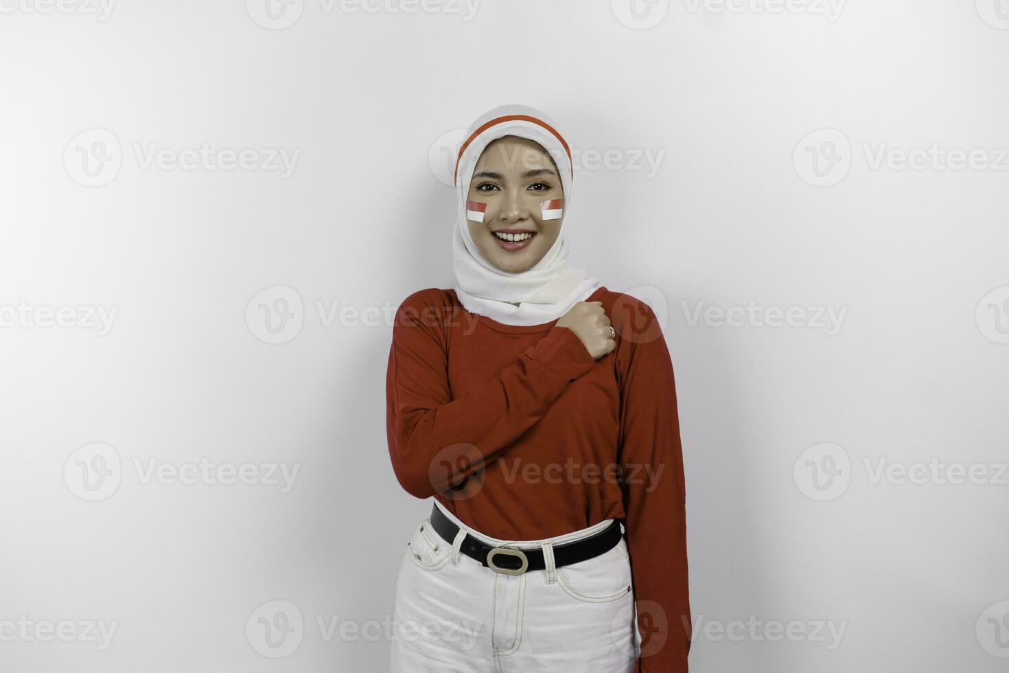 Beautiful Asian woman wearing red top and white hijab giving salute celebrate Indonesian independence day on August 17 isolated over white background photo