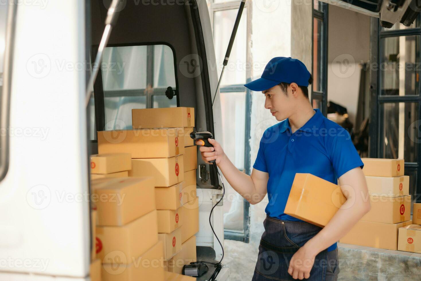 Smiling delivery man standing in front of his van with Holding Box and tablet delivery home and shipping photo