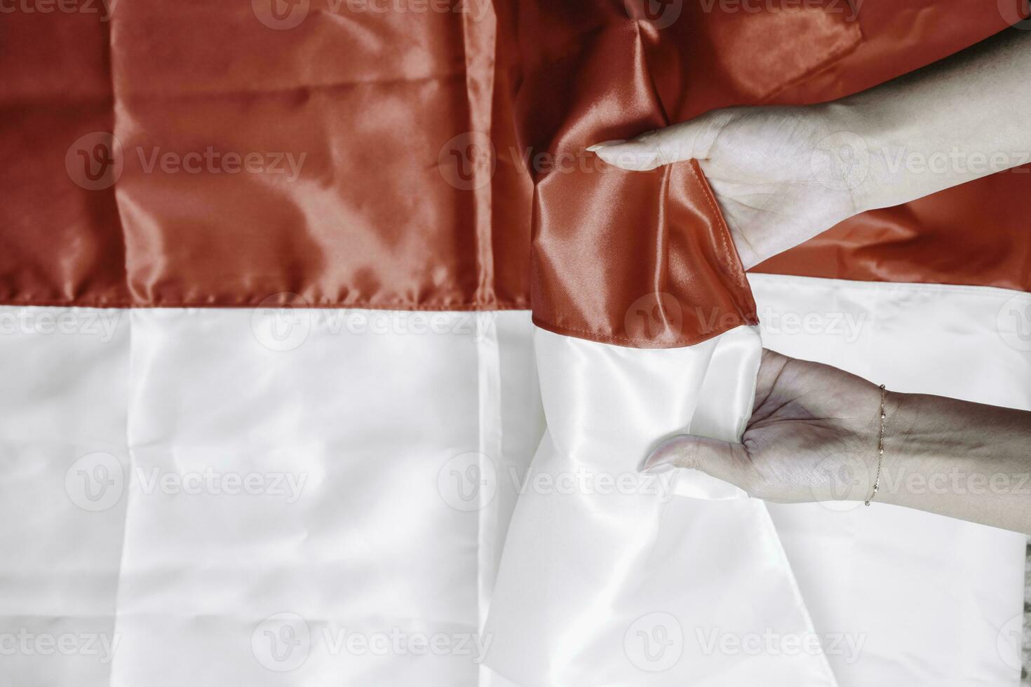 Hands put together holding Indonesian red and white flag. Indonesia's independence day concept photo