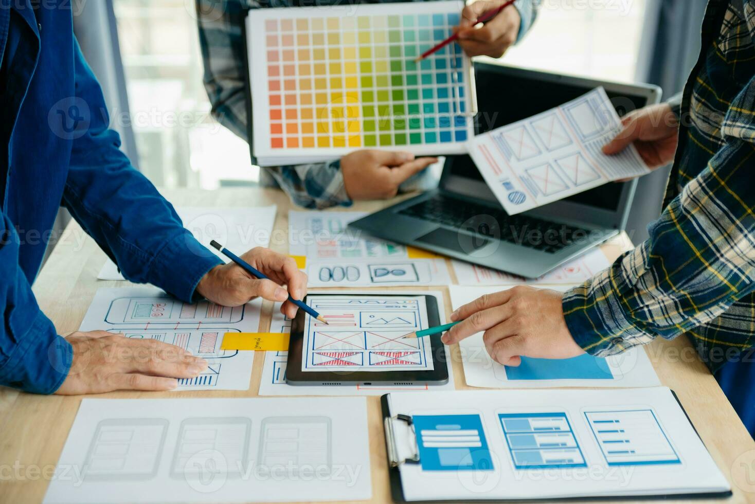 UX developer and ui designer brainstorming about mobile app interface wireframe design with customer breif and color code at modern office. photo