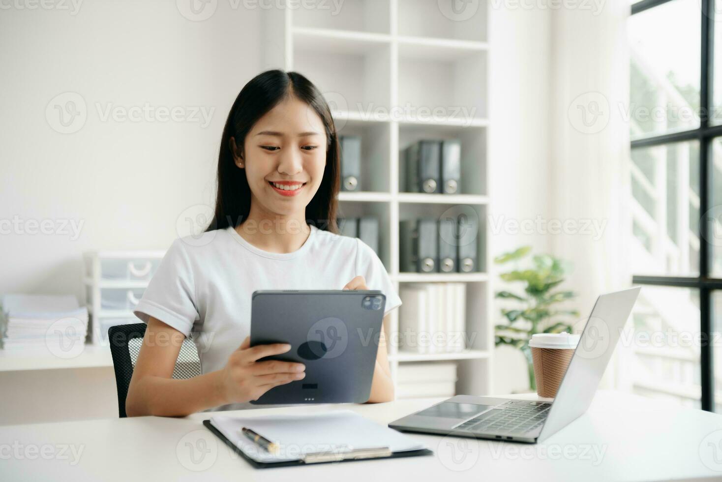 Business woman using tablet and laptop for doing math finance on an office desk, tax, report, accounting, statistics, and analytical research concept in office photo