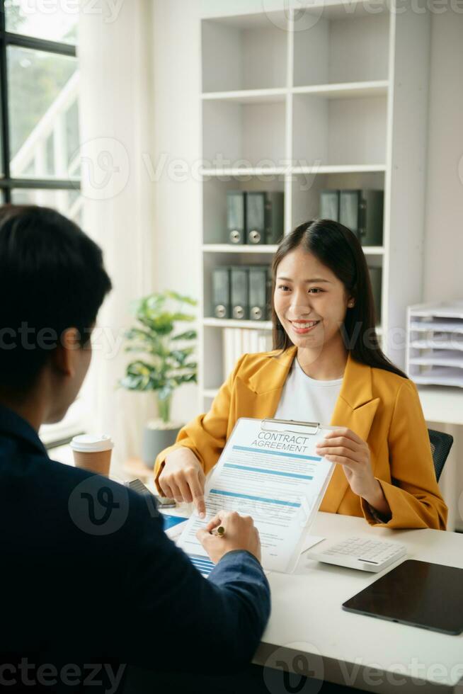 Signing a contract. Client and broker agent, lease agreement, successful deal and  Young business sitting at the desk in office photo