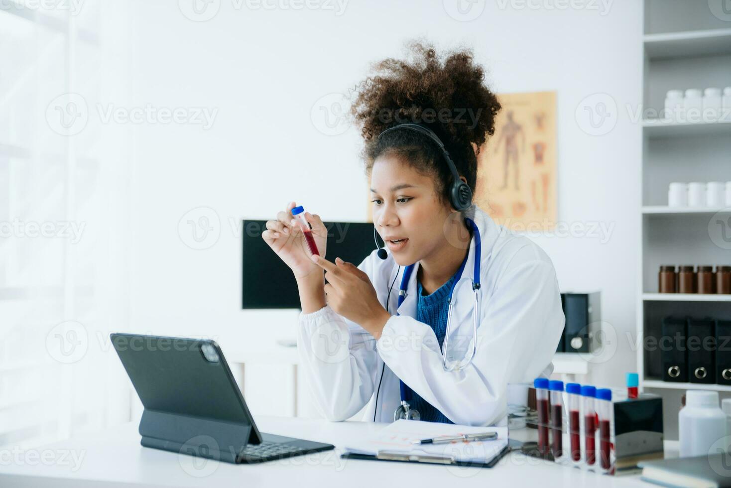 female doctor sitting on work desk Medical online, e health concept. Doctor using laptop for work, video call video chat with colleagues. photo