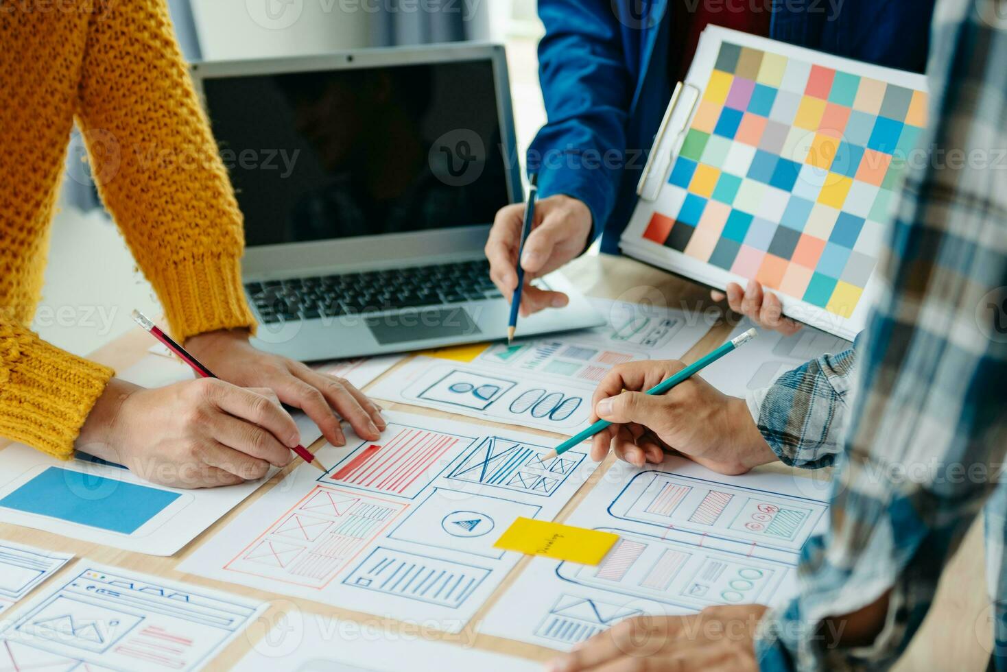 View of UI developer team brainstorming on their project with laptop, smartphone and digital tablet. Creative digital development agency. photo
