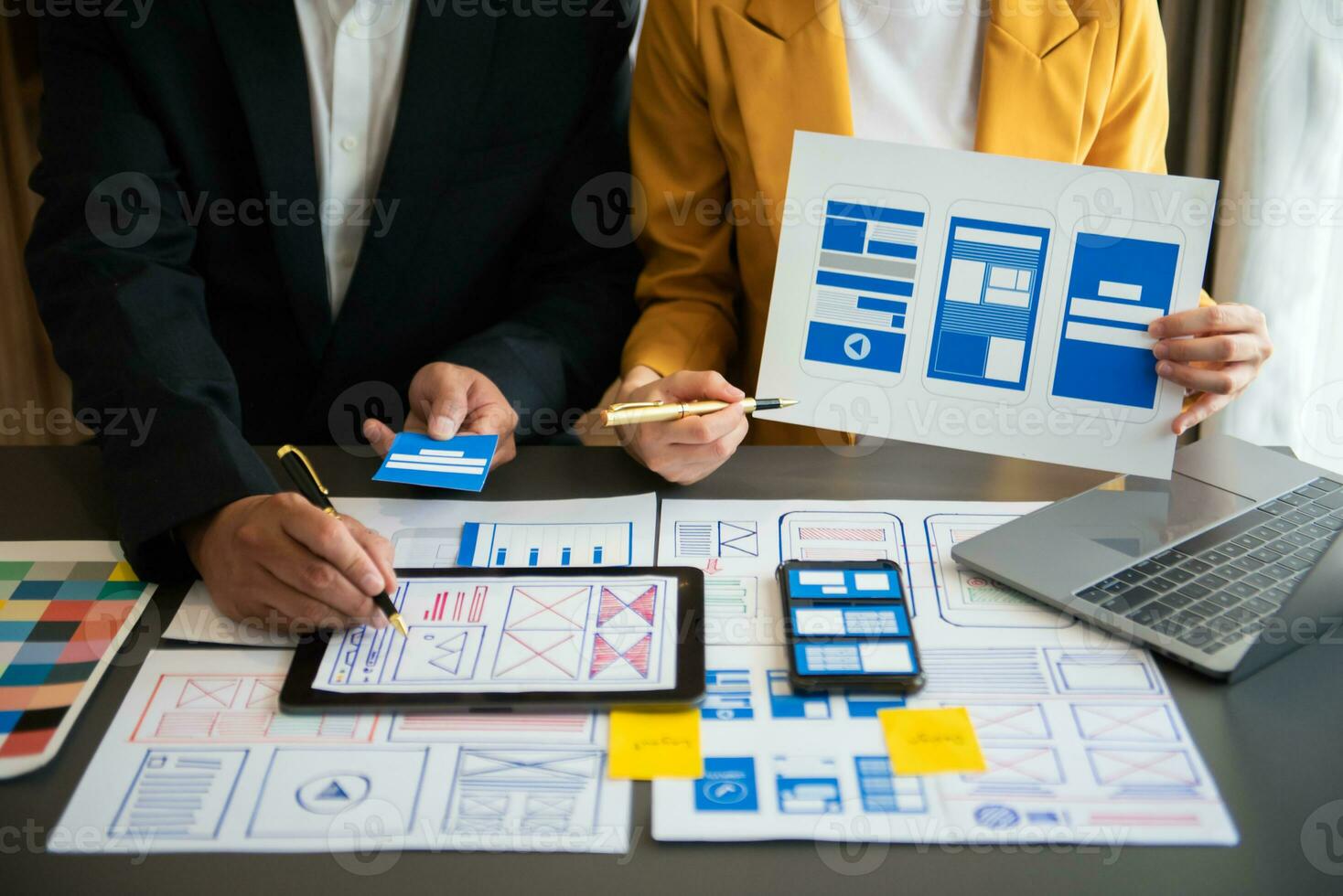 UX developer and ui designer brainstorming about mobile app interface wireframe design with customer breif and color code at office. photo