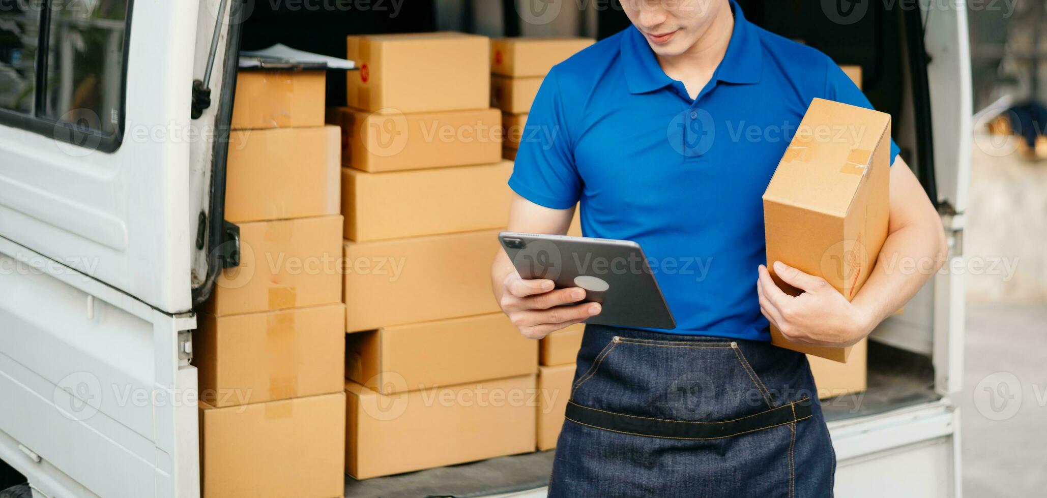 Portrait of courier delivery Asian man searching the address on digital tablet. Delivery service, delivery home and shipping concept. photo