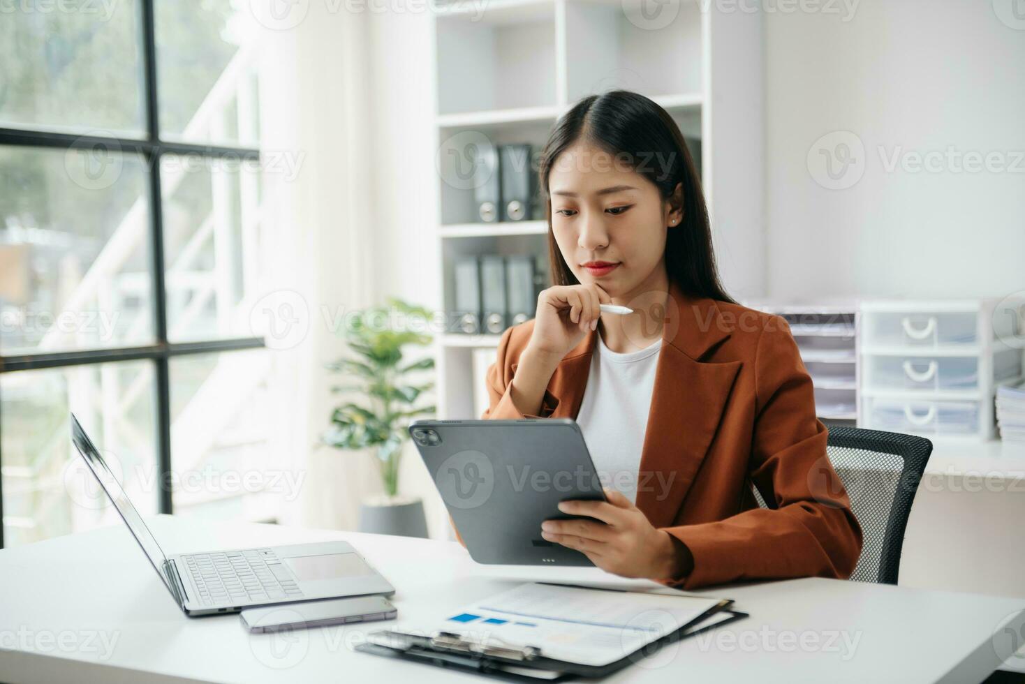 Business woman using tablet and laptop for doing math finance on an office desk, tax, report, accounting, statistics, and analytical research concept in office photo