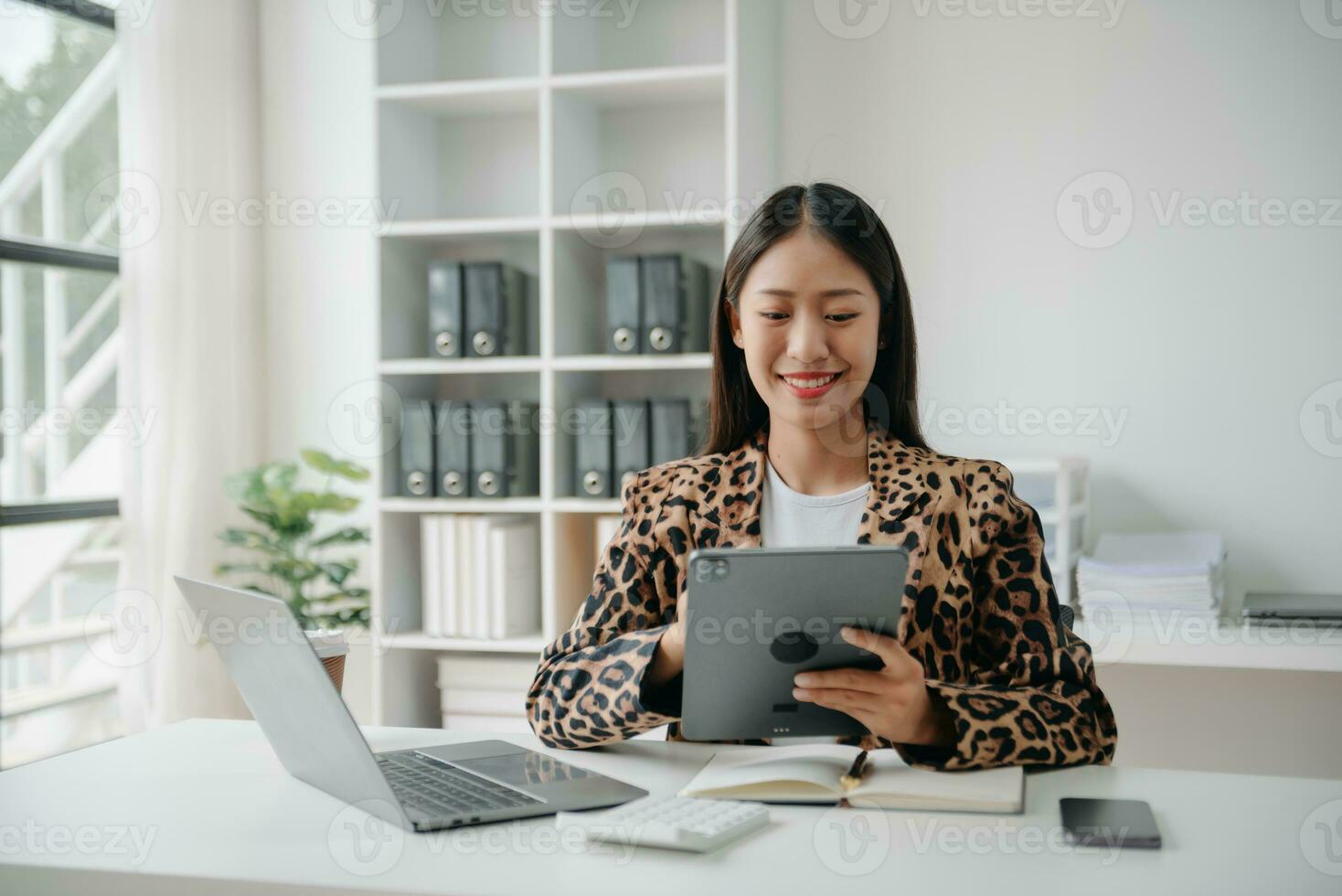 Business woman using tablet and laptop for doing math finance on an office desk, tax, report, accounting, statistics, and analytical research concept in office photo