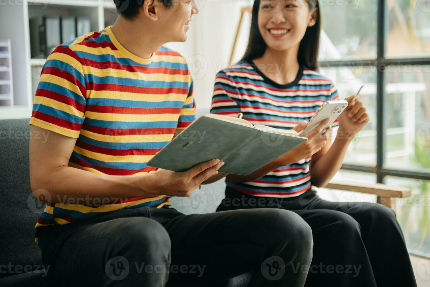 Two asian students learning together online with a laptop, tablet and tutor together in living room at home. photo