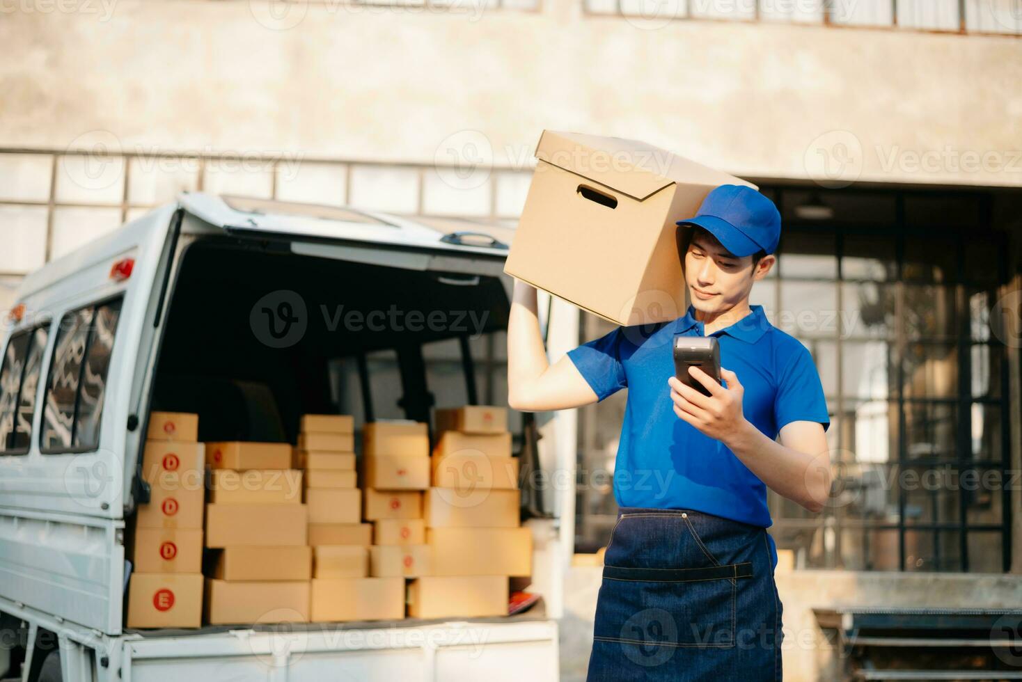 Smiling delivery man standing in front of his van with Holding Box and tablet delivery home and shipping photo