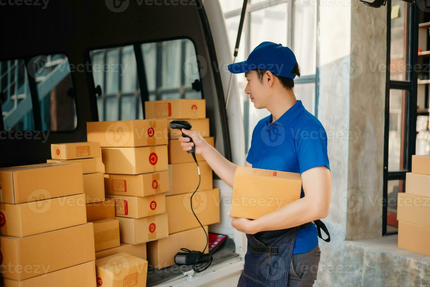 Smiling delivery man standing in front of his van with Holding Box and tablet delivery home and shipping photo