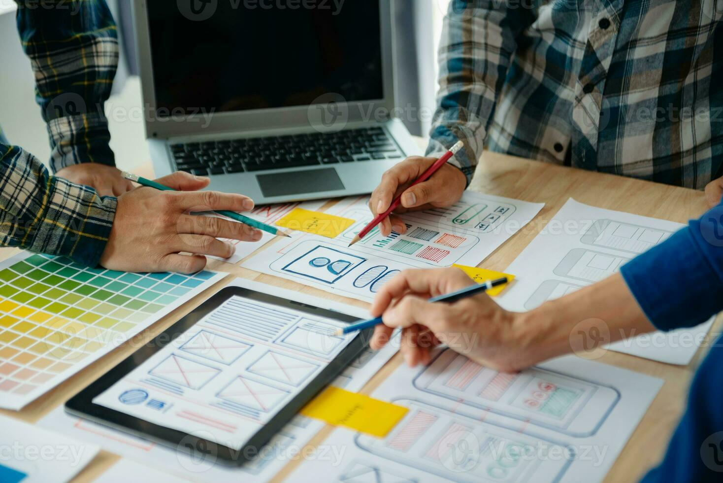 UX developer and ui designer brainstorming about mobile app interface wireframe design with customer breif and color code at modern office. photo