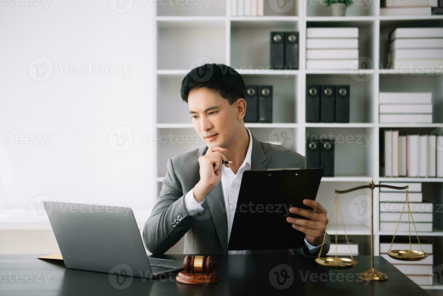 Attractive young lawyer in office Business man and lawyers discussing contract papers laptop and tablet with brass scale on  desk in office. photo