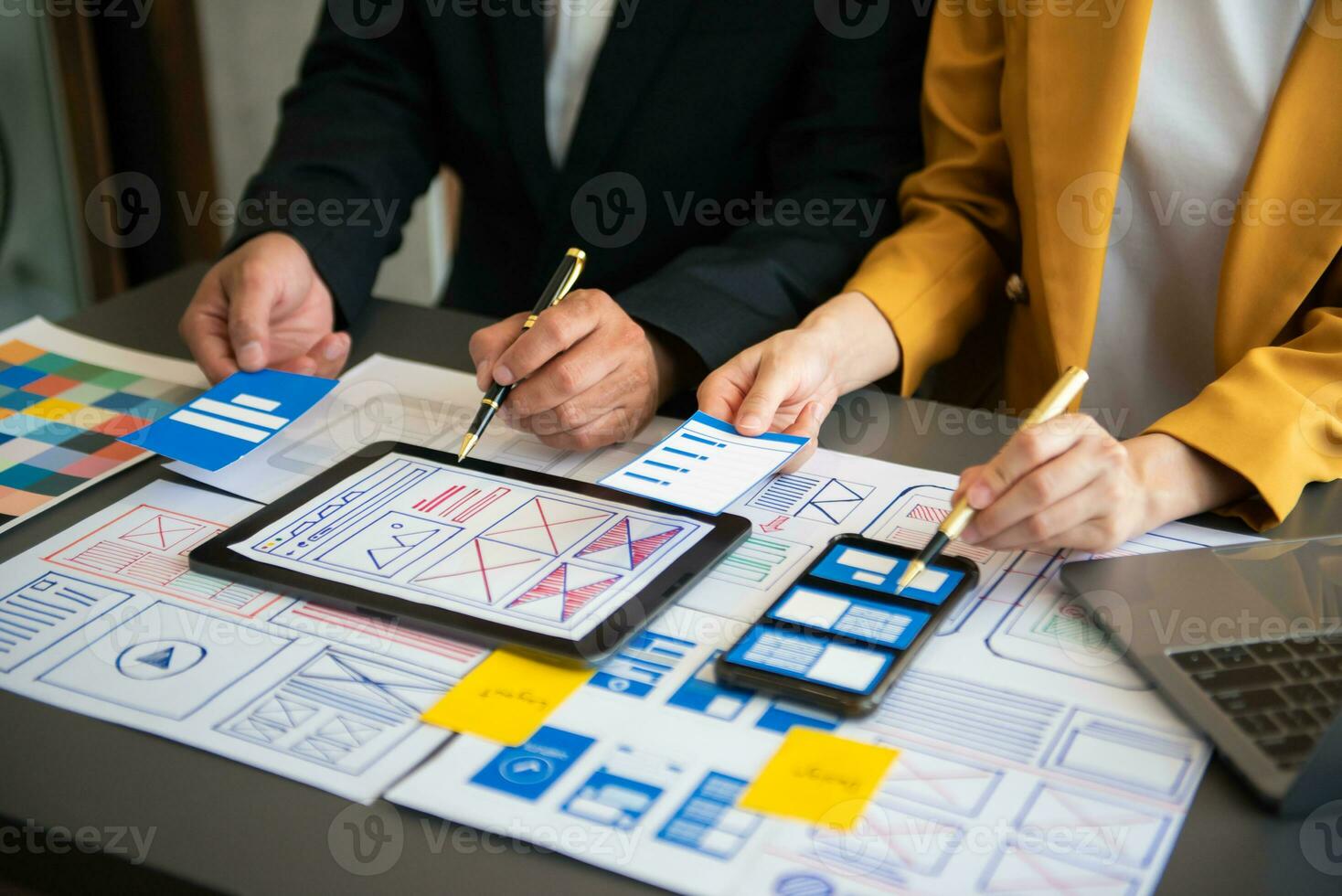 UX developer and ui designer brainstorming about mobile app interface wireframe design with customer breif and color code at office. photo