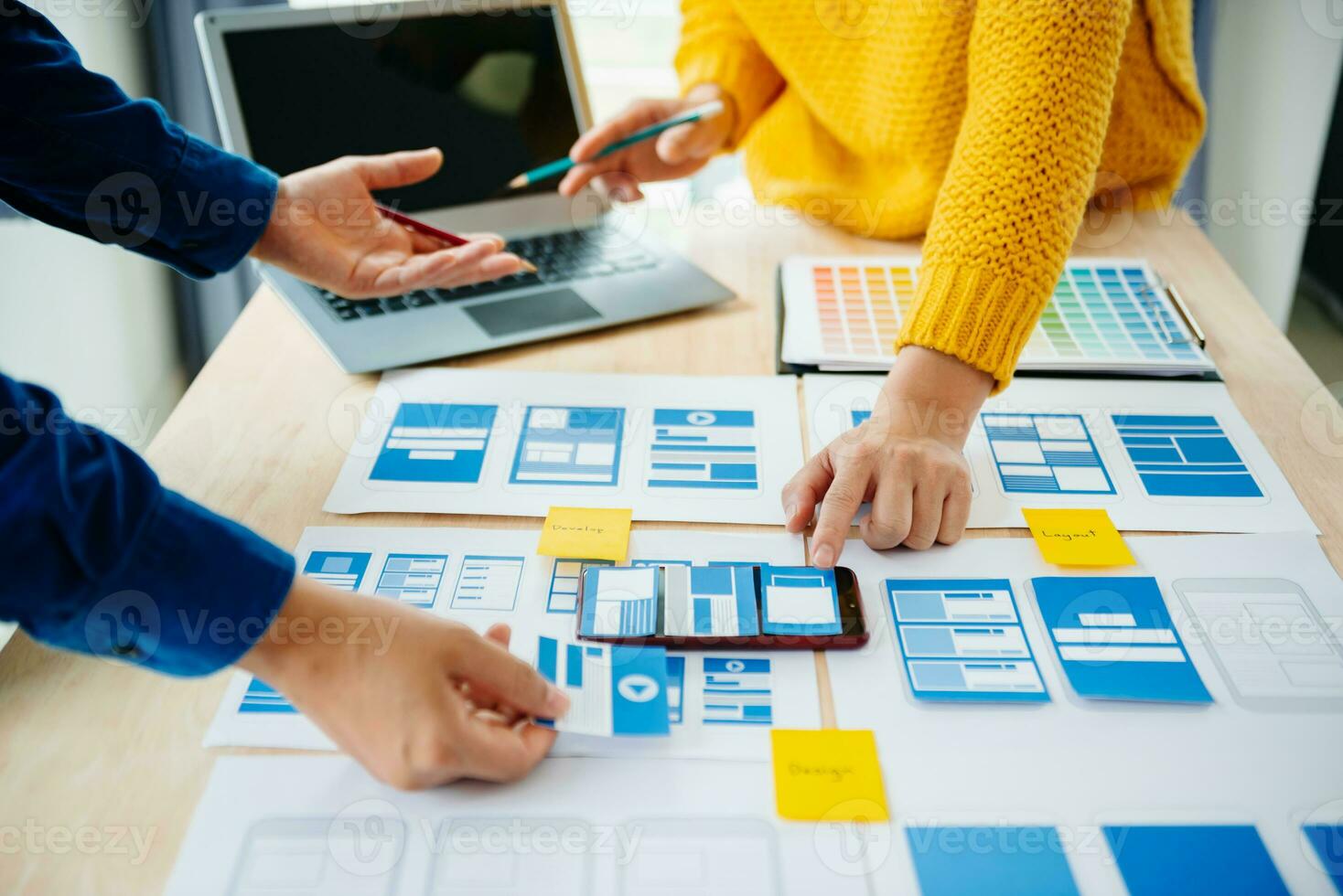 View of UI developer team brainstorming on their project with laptop, smartphone and digital tablet. Creative digital development agency. photo