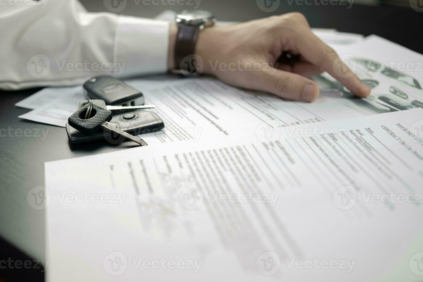 hombre firma coche seguro documento o arrendamiento papel. escritura firma en contrato o acuerdo. comprando o de venta nuevo o usado vehículo. coche llaves en de madera mesa. garantía o garantizar. foto