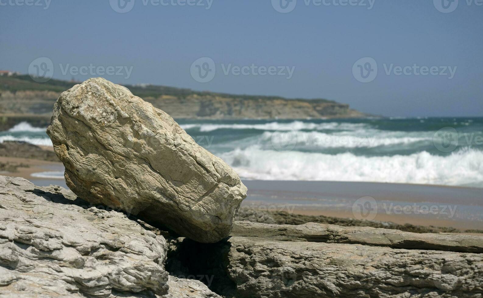 selectivo atención en un más atrevido con olas llegando a el costa de ericeira, Portugal, en el antecedentes foto