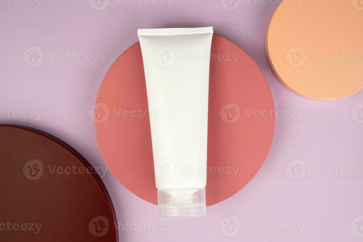 White cosmetic tube packaging mockup on podium flat lay photo