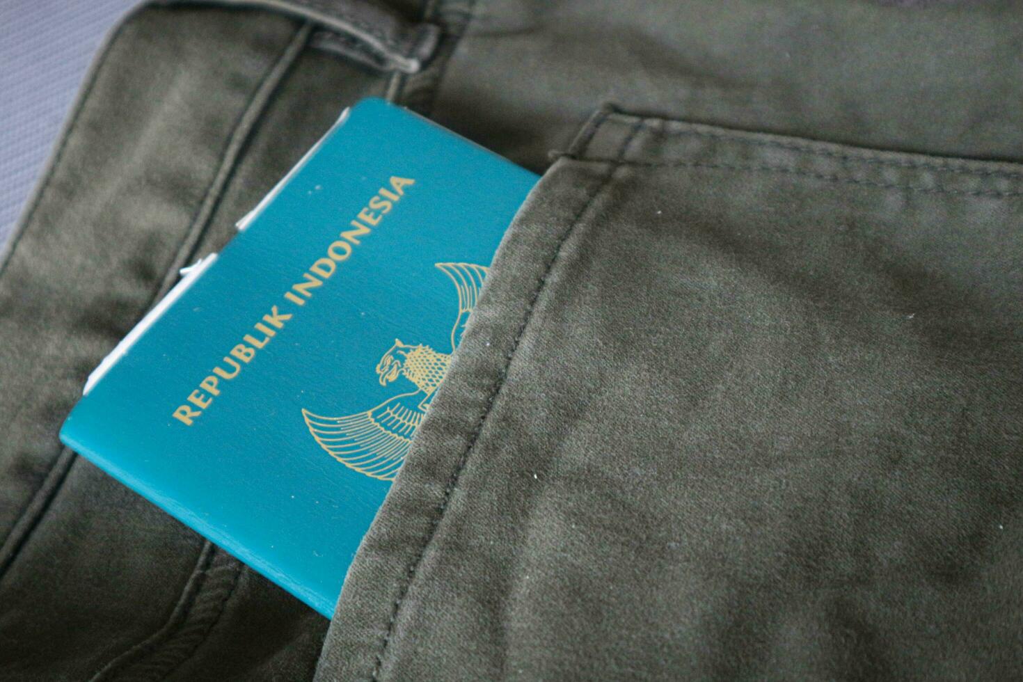 An Indonesian citizenship passport in a green denim pocket. photo