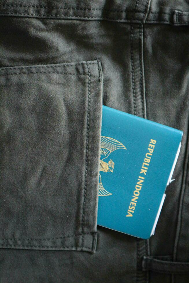 An Indonesian citizenship passport in a green denim pocket. photo