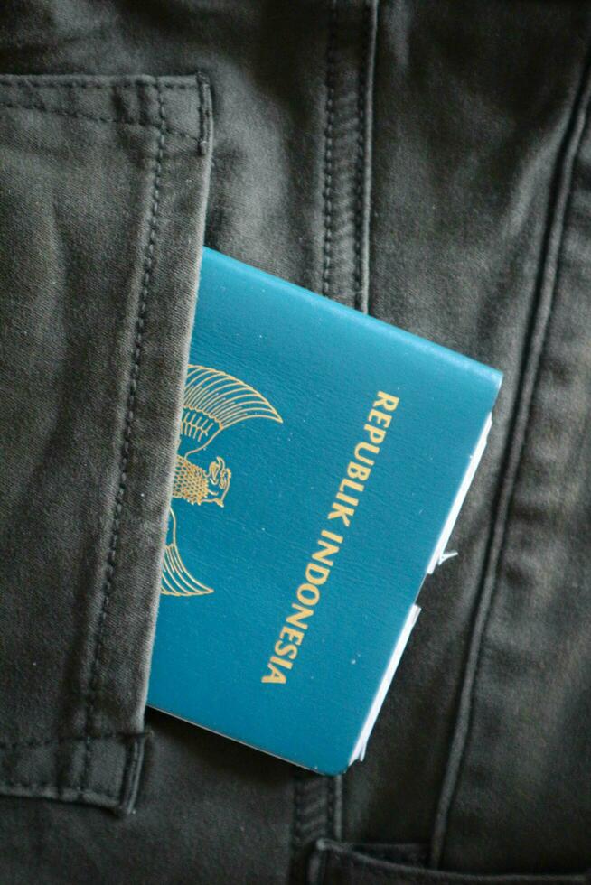 An Indonesian citizenship passport in a green denim pocket. photo