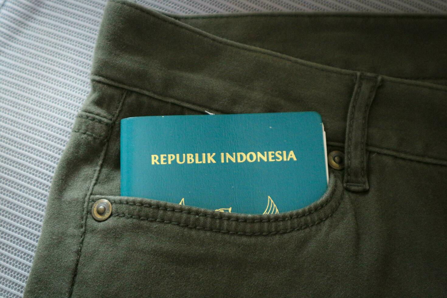 An Indonesian citizenship passport in a green denim pocket. photo