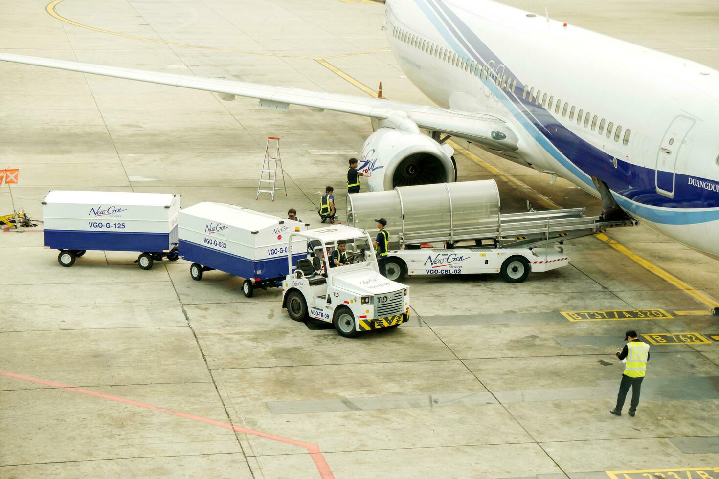 Bangkok, Thailand, 2018 - New gen airline staff using cargo cart delivery baggage to loader cart loading luggage to the airplane. photo