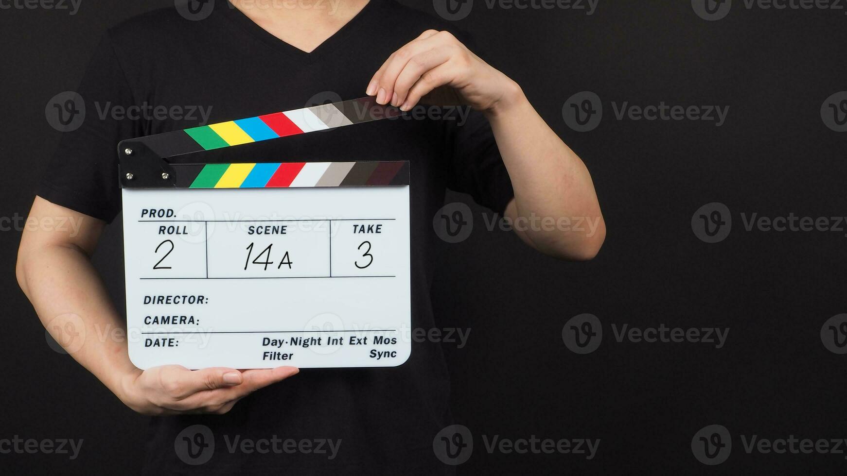 Hand is holding clapper board or movie slate with write in number on black background. photo