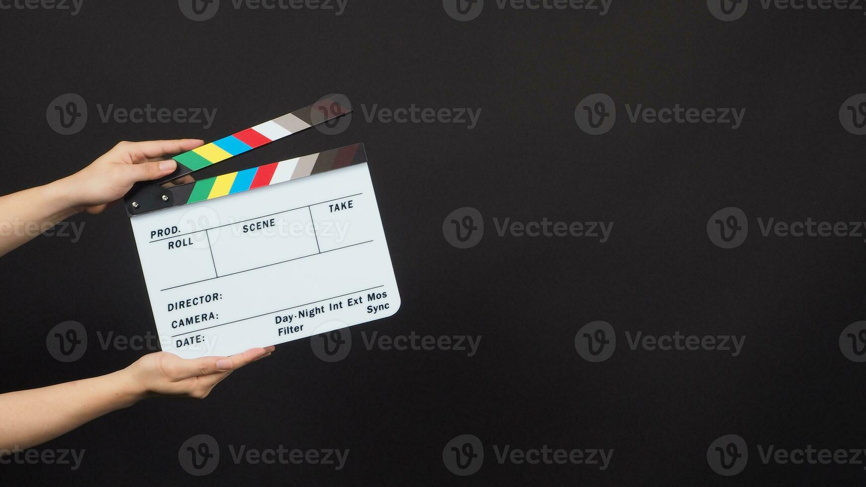 Hand is holding movie slate.It is used in video production and film industry on black background. photo