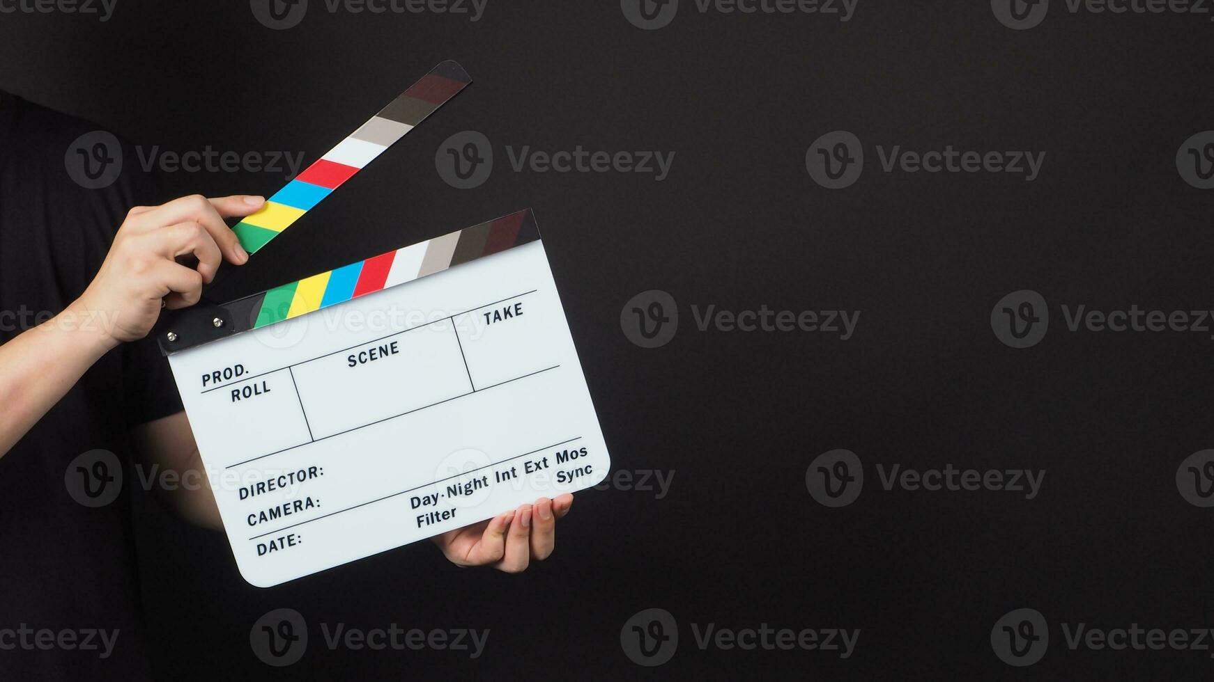 Hand is holding movie slate.It is used in video production and film industry on black background. photo