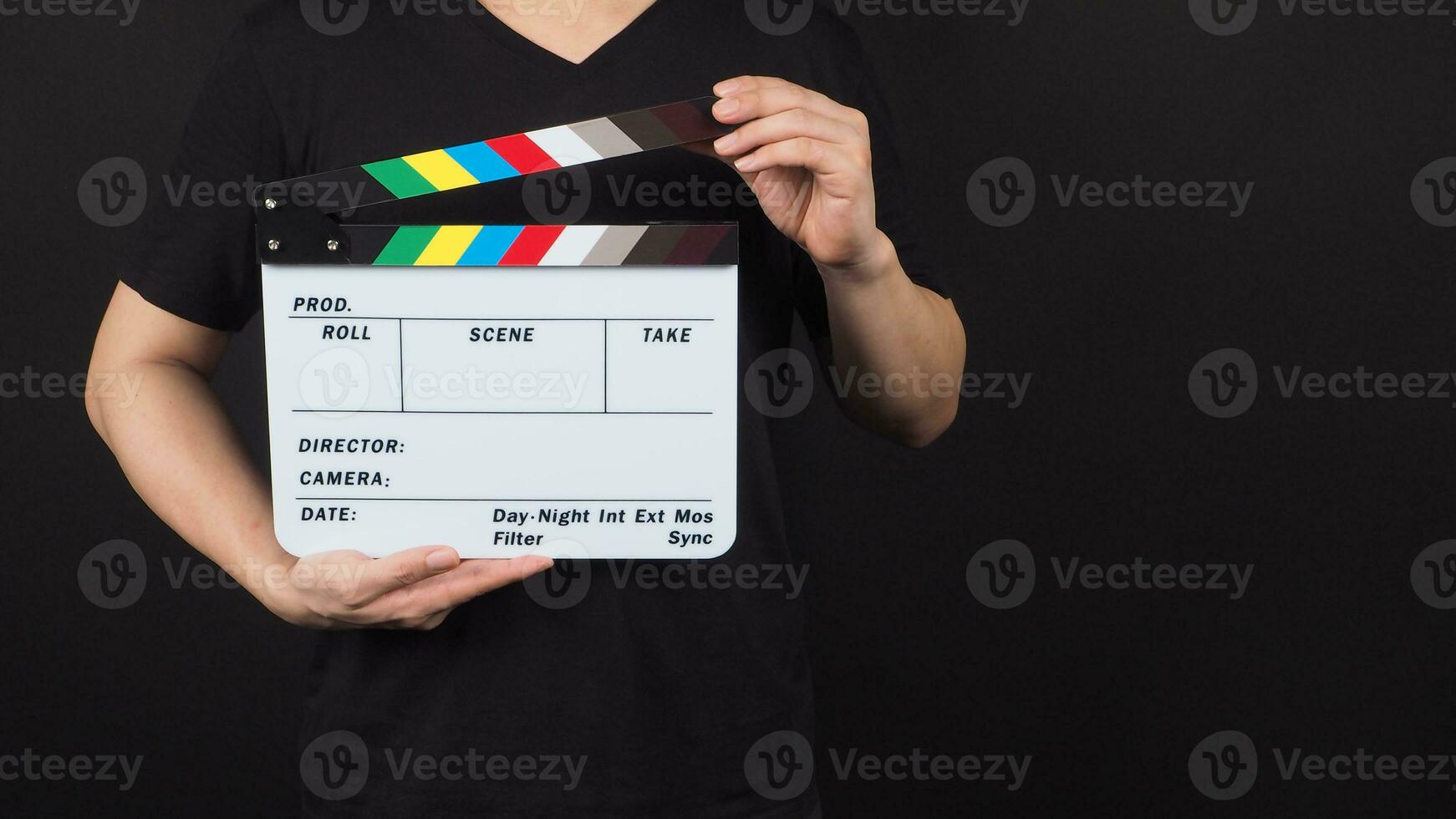 hand is holding movie slate.It is used in video production and film industry on black background. photo