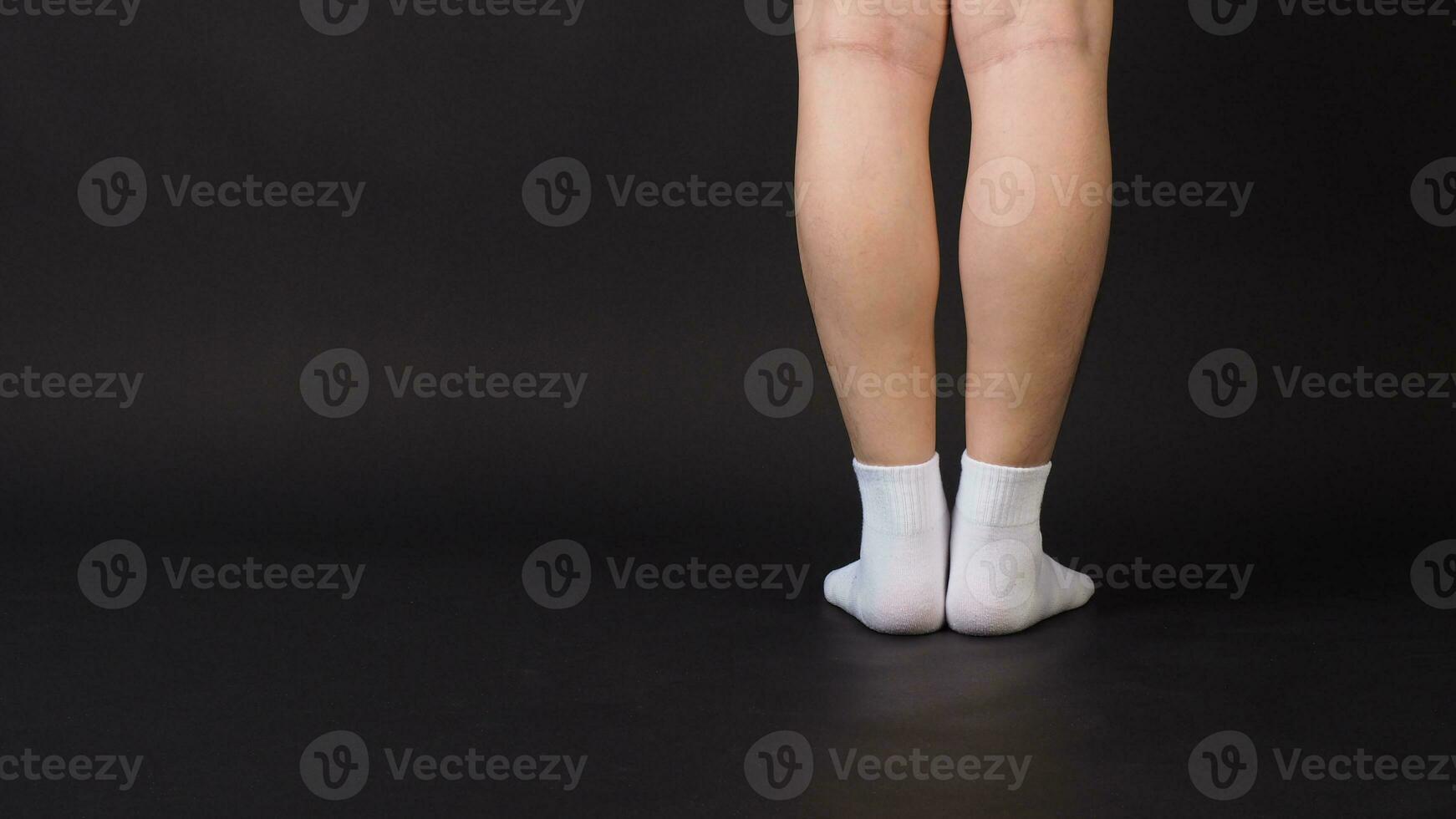 Asian Male legs wear white sock is isolated on black background photo