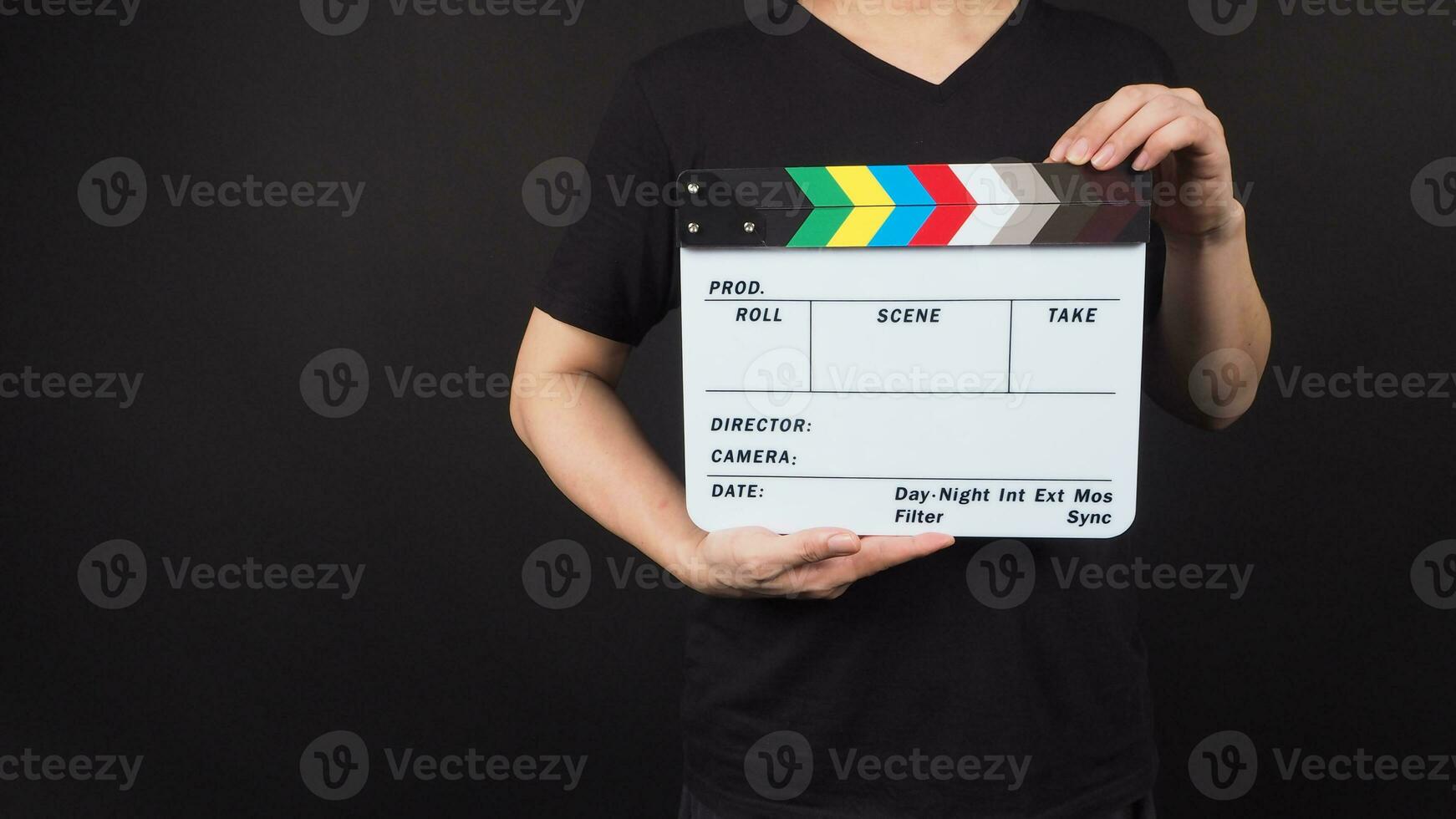 clapperboard or movie clapper board in man hand.It is used in video production and film industry on black background. photo