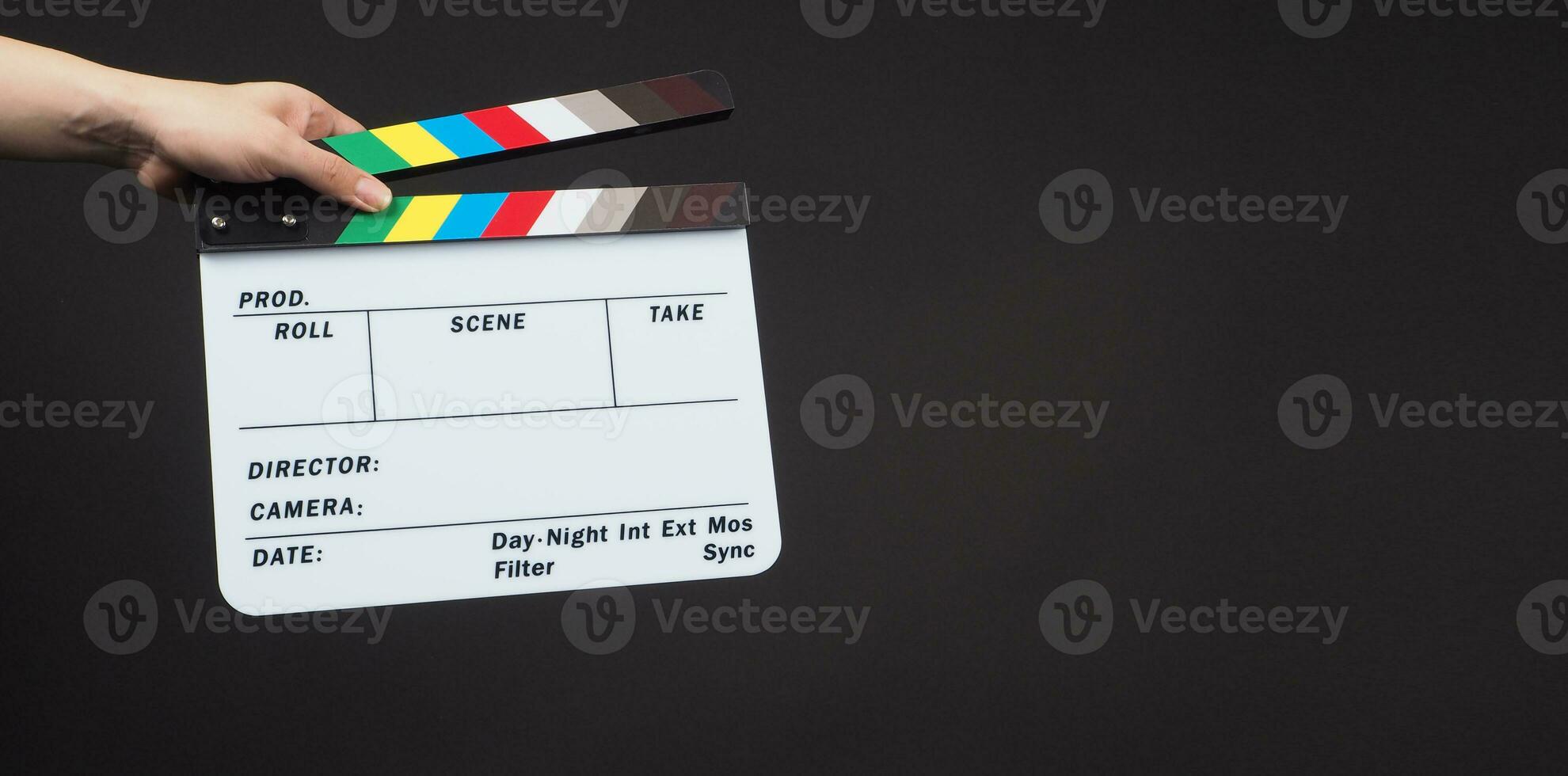 Hand is holding clapper board or movie slate.It is used in video production and film industry on black background. photo