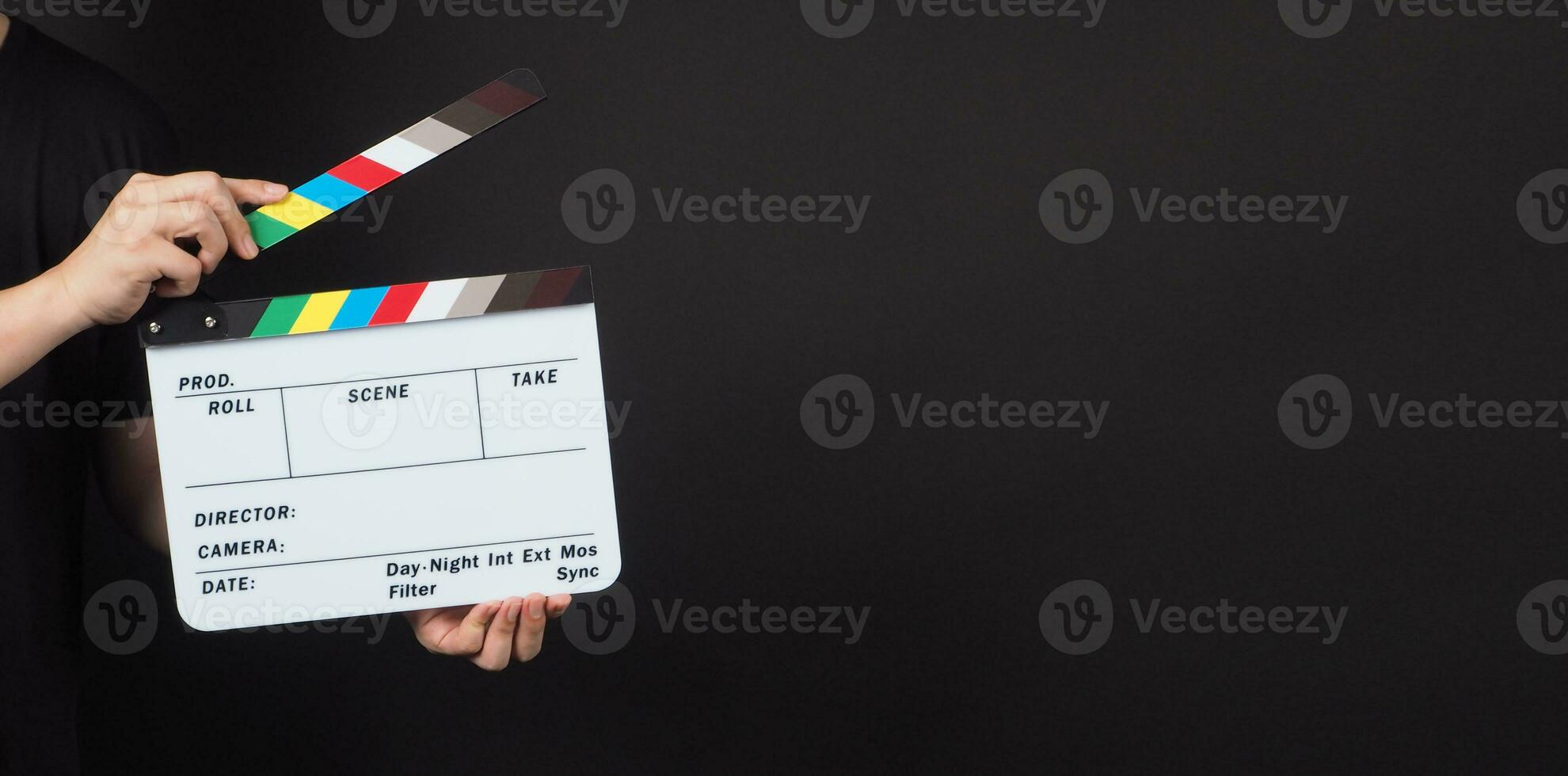 clapperboard or movie clapper board in man hand.It is used in video production and film industry on black background. photo