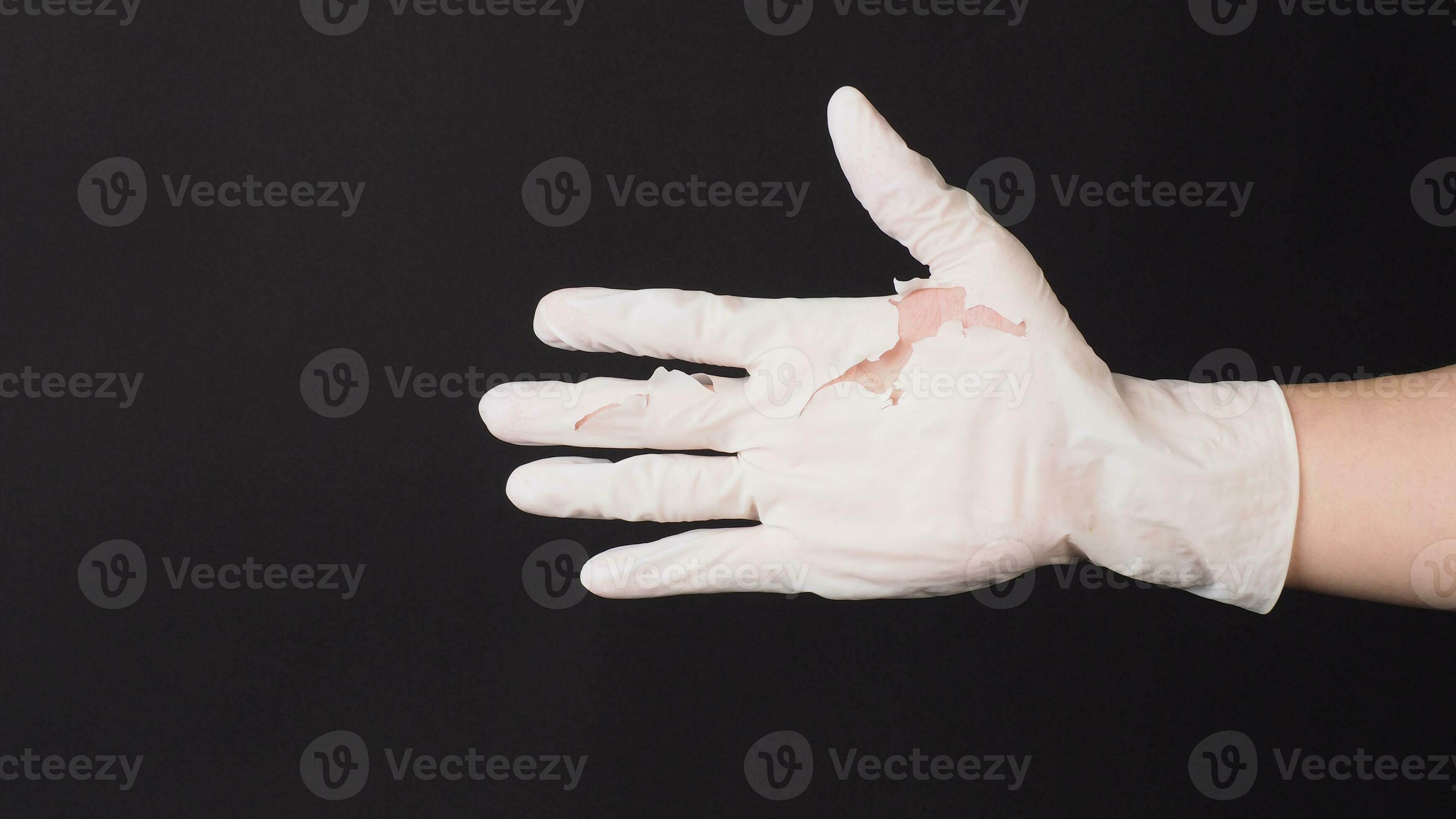 Hand Wearing torn latex glove or torn rubber gloves on black background