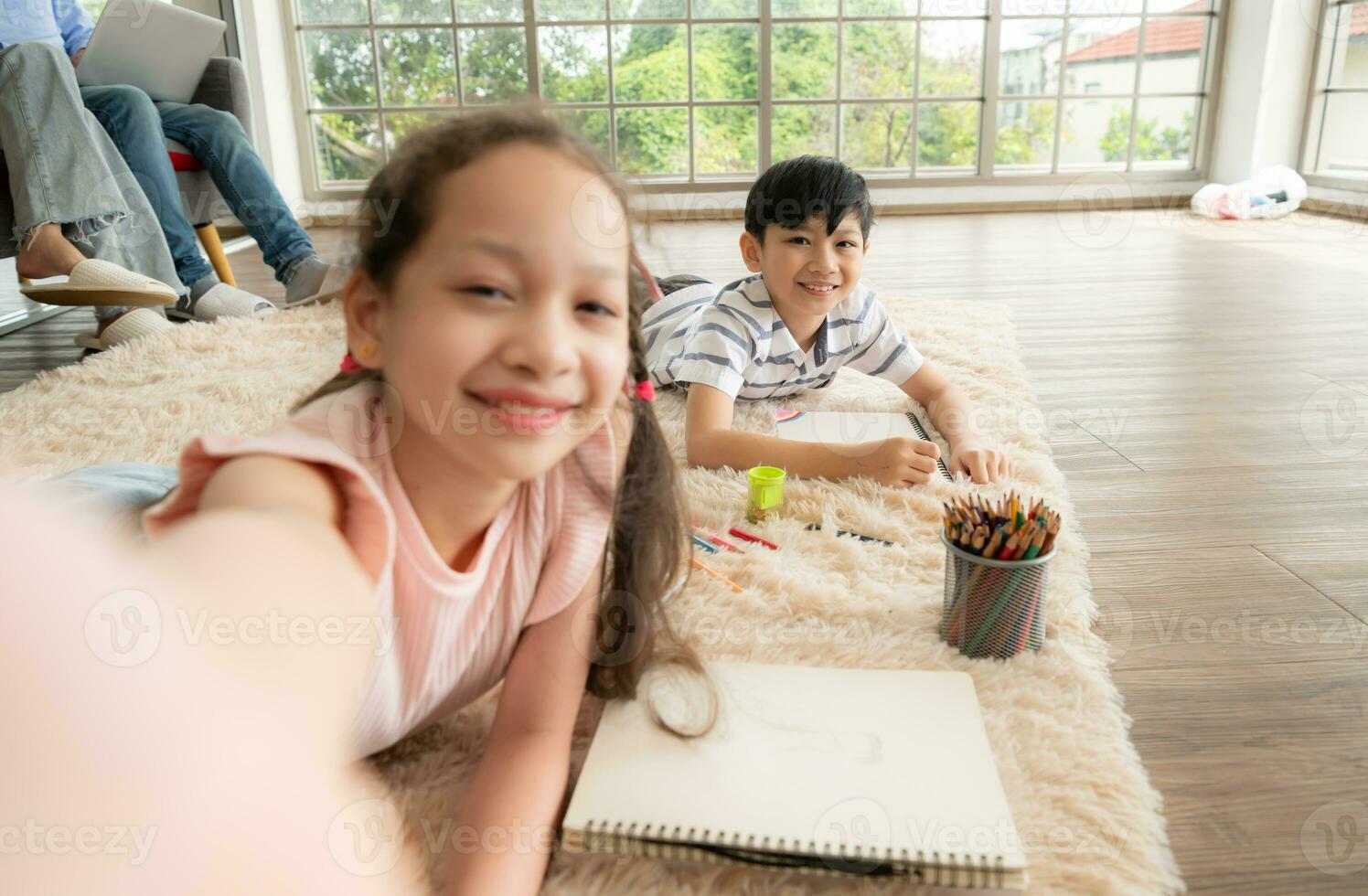 A boy and a daughter from an asian family. The children are having fun in the art of drawing and selfie of themselves on social media. photo