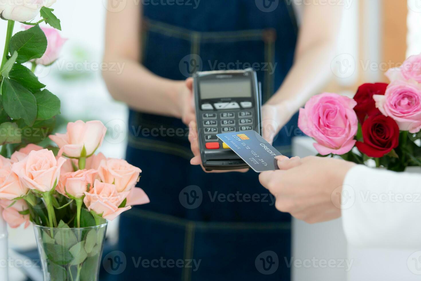 Cropped shot of female florist giving credit card to customer photo