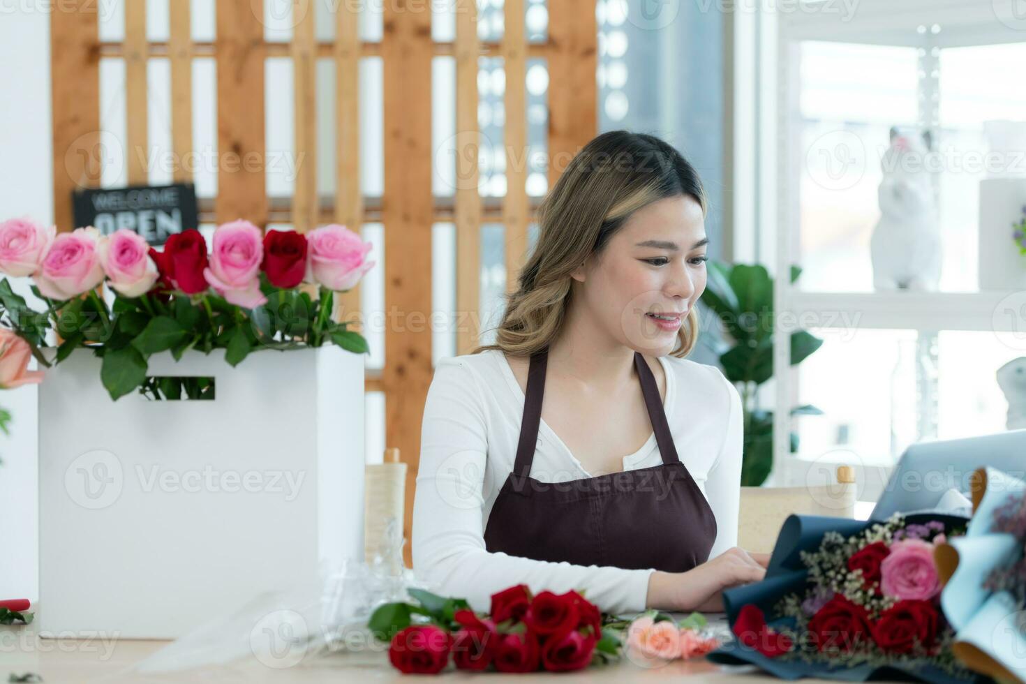 hermosa asiático mujer florista trabajando en flor tienda. foto