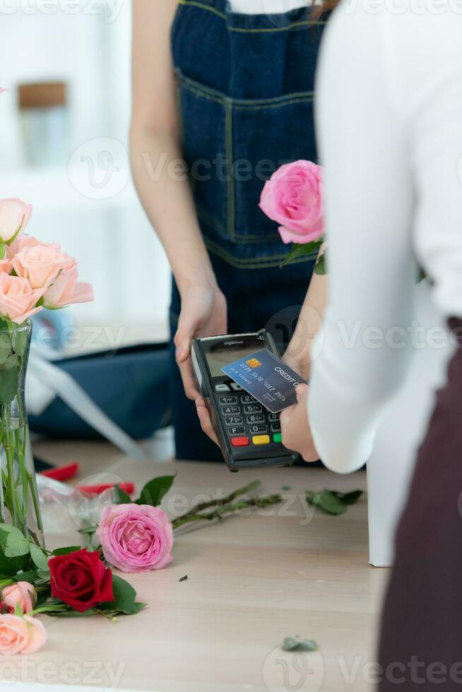 recortado Disparo de hembra florista dando crédito tarjeta a cliente foto
