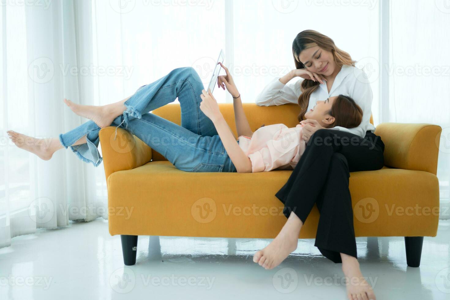 LGBT couple sitting on sofa and using laptop computer at home. photo