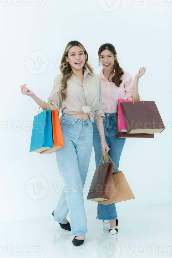 dos contento asiático mujer participación compras pantalones aislado en blanco antecedentes. foto