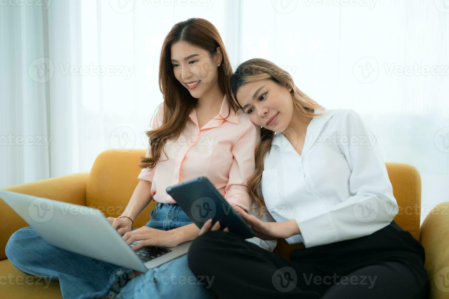 LGBT couple sitting on sofa and using laptop computer at home. photo