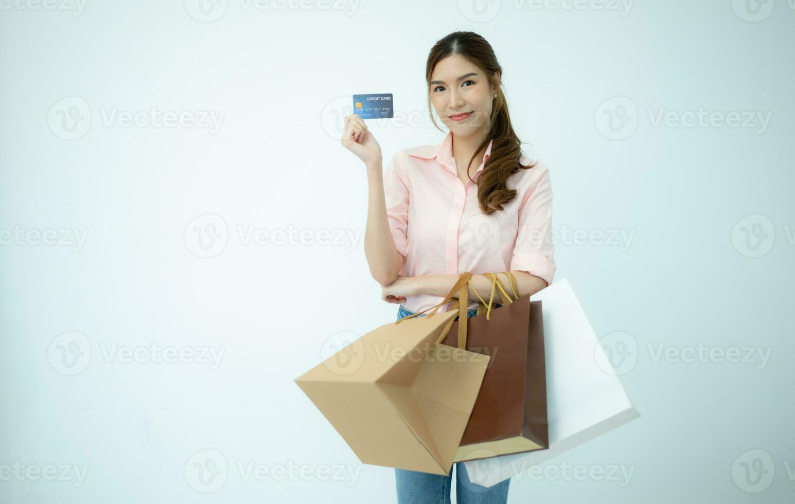 Happy woman holding shopping bags and credit card isolated on white background. photo