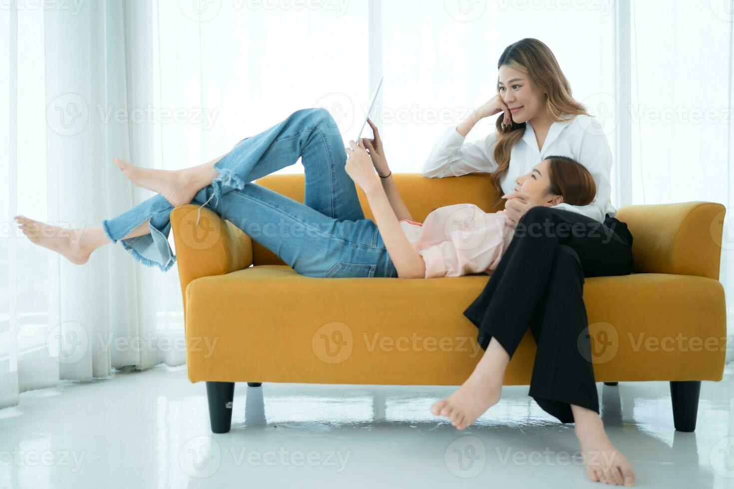 LGBT couple sitting on sofa and using laptop computer at home. photo